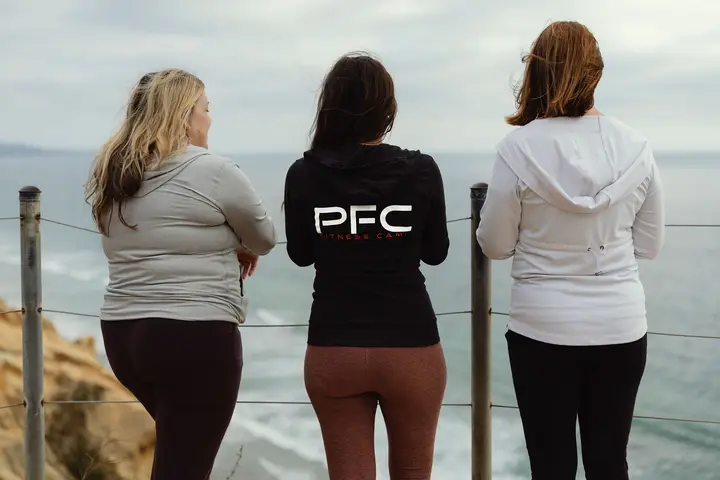 Three PFC guests looking out at the Pacific from a coastal trail