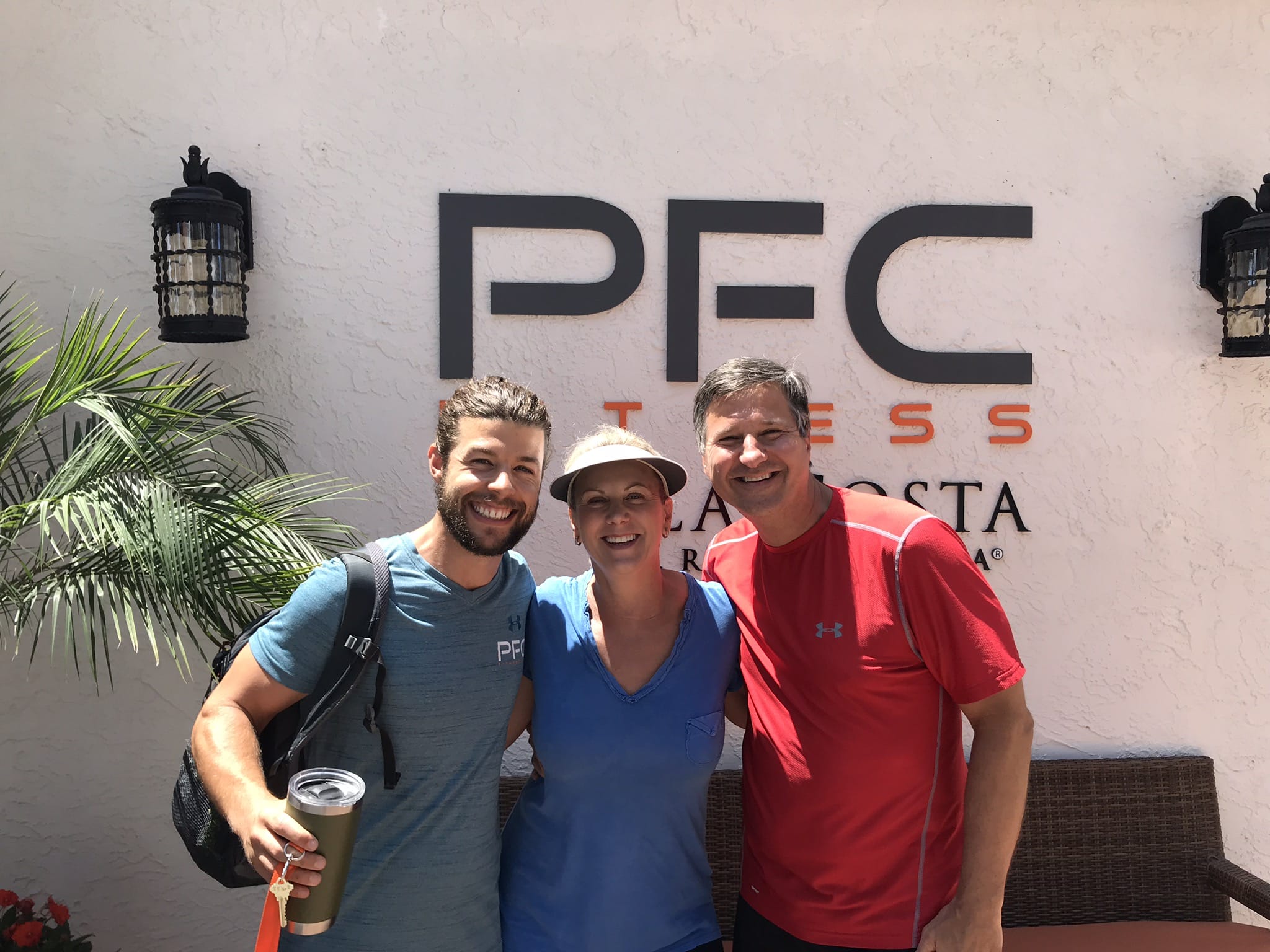 weight loss camp participants stand in front of PFC sign at resort