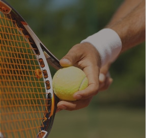 person holds tennis racket & ball
