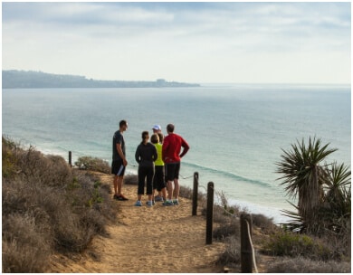 PFC hiking participants on sandy path leading to the ocean