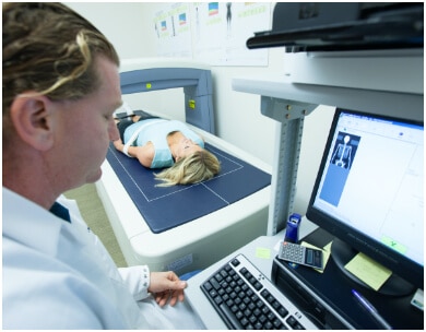 Doctor assists woman getting a body scan for wellness