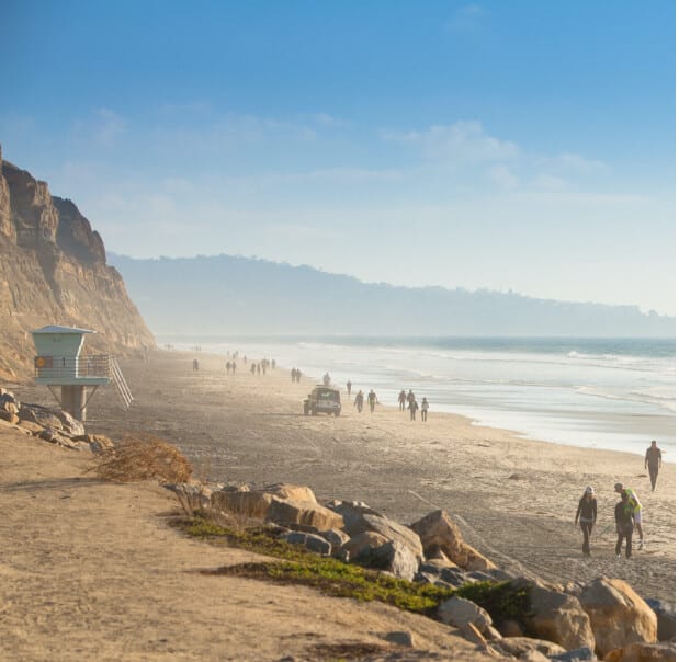 People walk along the beach in California