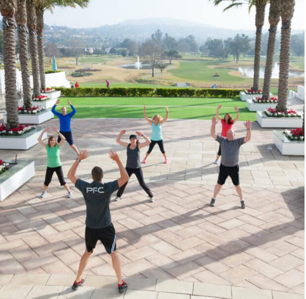 Participants at the Premier Fitness camp for weight loss do jumping jacks together outside at La Costa Resort