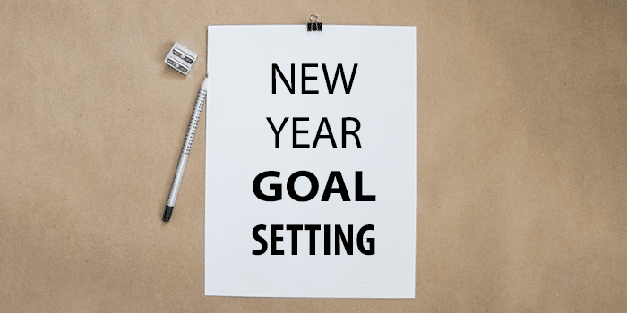paper with NEW YEAR NEW GOAL SETTING written on it against brown background