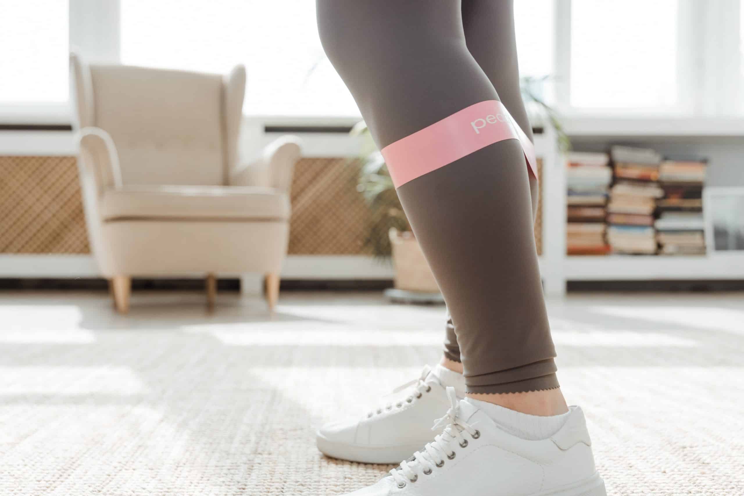 legs with workout band across calves in woman's living room