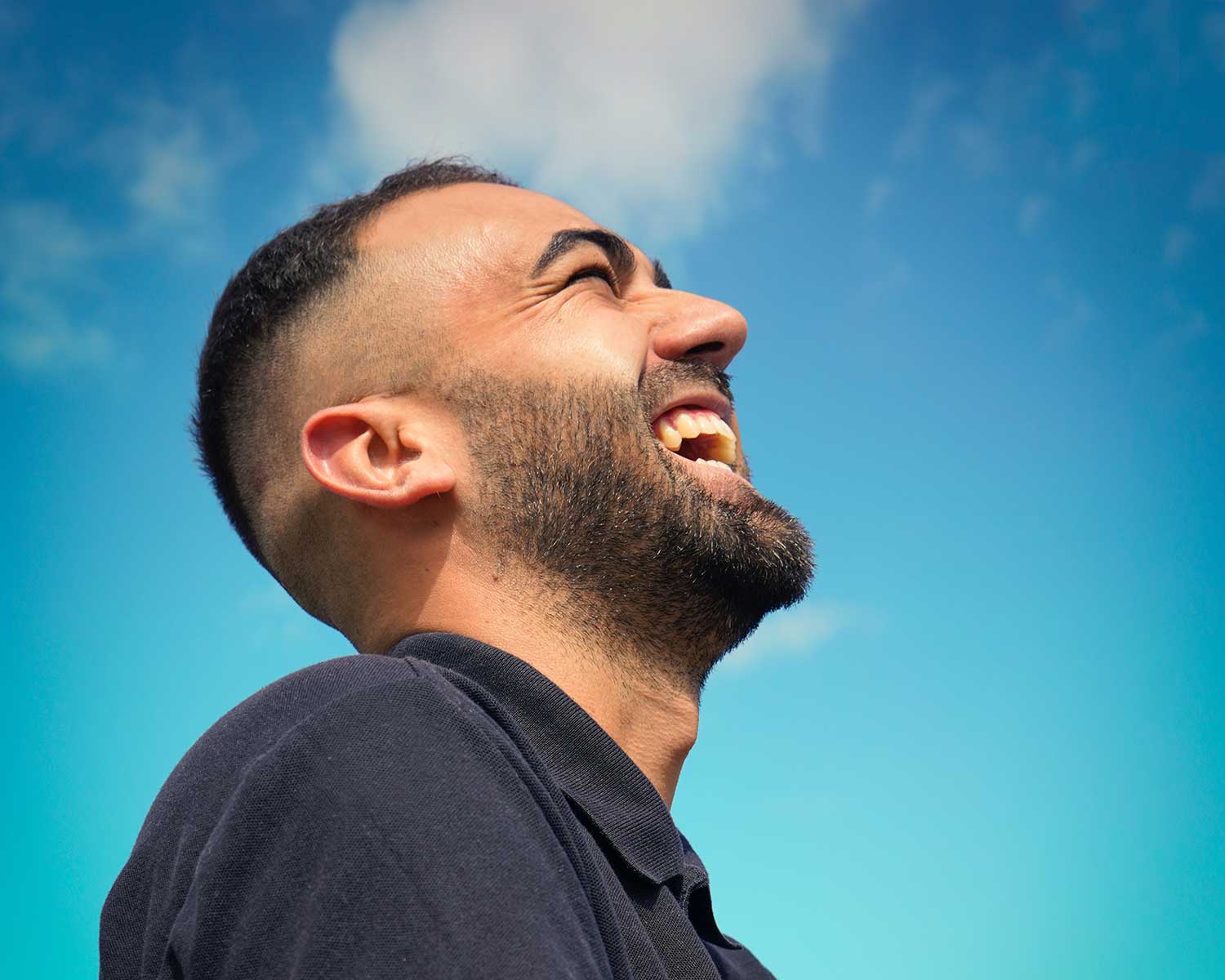 man with beard laughs & smiles