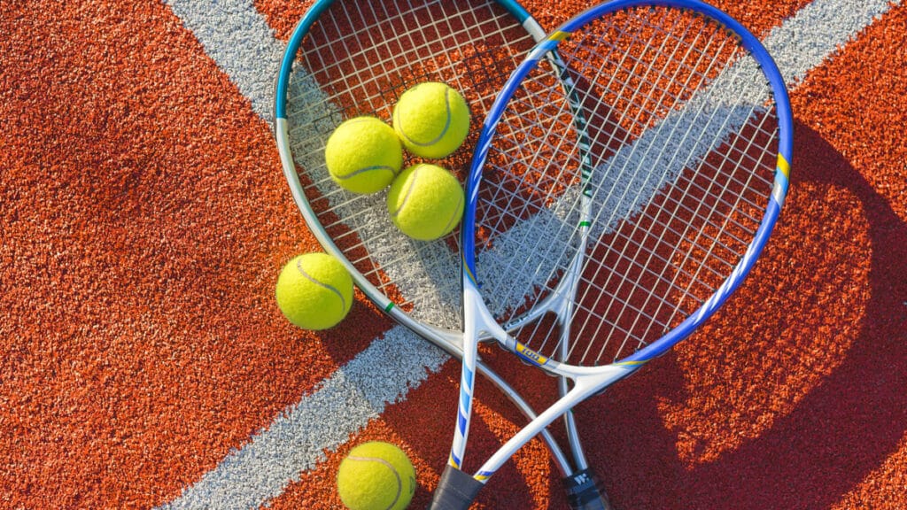 tennis rackets and tennis balls on a court at premier fitness camp