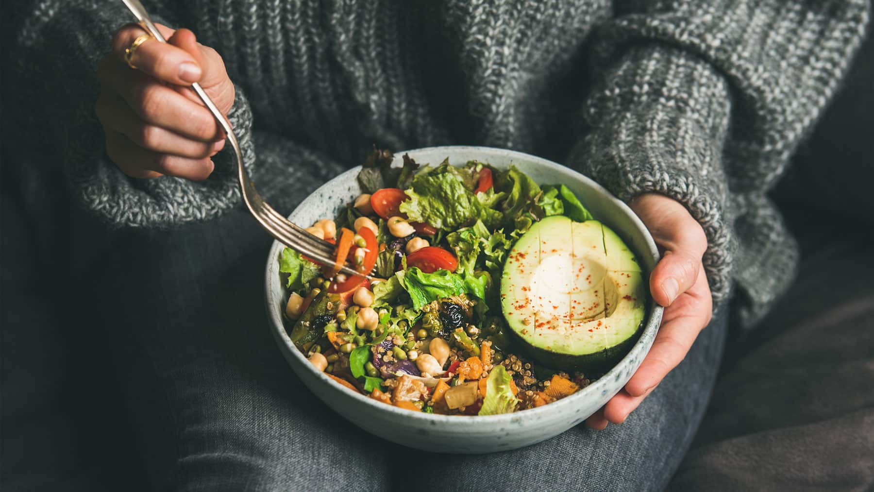person holds bowl with fresh chicken & avocado bowl for clean eating